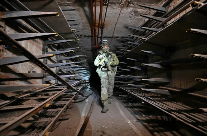 Un soldat russe inspecte un tunnel sous l'aciérie Azovstal de Marioupol, prise à l'Ukraine, le 13 juin 2022