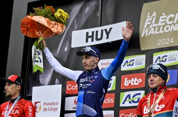 Le Britannique Stephen Williams (c) vainqueur de la Flèche Wallonne devant le Français Kévin Vauquelin (g) et le Belge Maxim Van Gils (d), le 17 avril 2024 au Huy (Belgique)