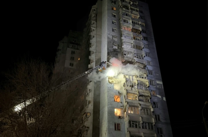 Des pompiers ukrainiens éteignent un incendie dans un immeuble résidentiel causé par une frappe russe sur Zaporijjia dans le sud de l'Ukraine le 24 mars 2026