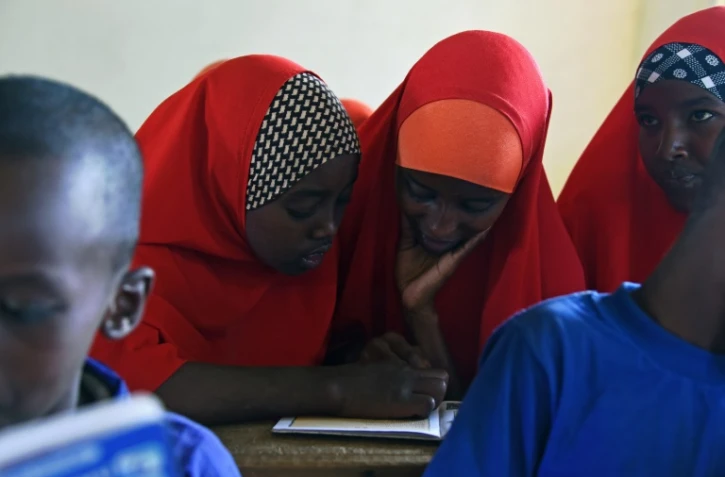 Halima (c, d) mariée à 13 ans étudie dans une classe à Wajir, le 28 septembre 2016