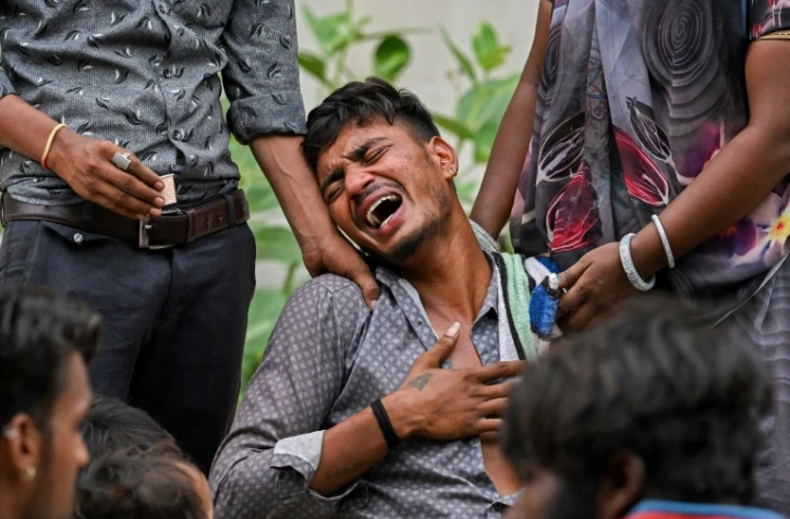 Kalpesh Patni (au centre) pleure la mort de son frère Akash, 14 ans, tué dans son sommeil par le crash de l'avion d'Air India sur son domicile à Ahmedabad, en Inde, le 13 juin 2025