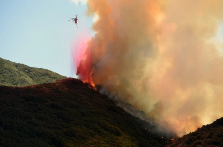 Un hélicoptère survole l'incendie qui fait rage à Keenbrook, en Californie, le 18 août 2016