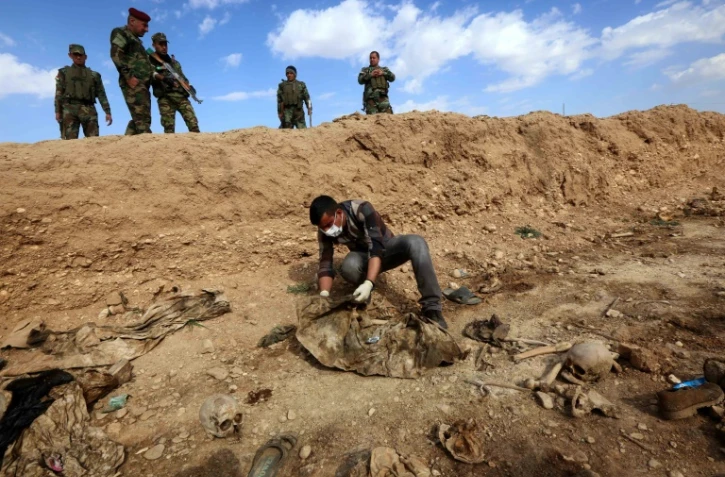 Un Iraquien inspecte les restes des corps de Yazidis tués par l'EI le 3 février 2015 au nord-ouest de l'Irak