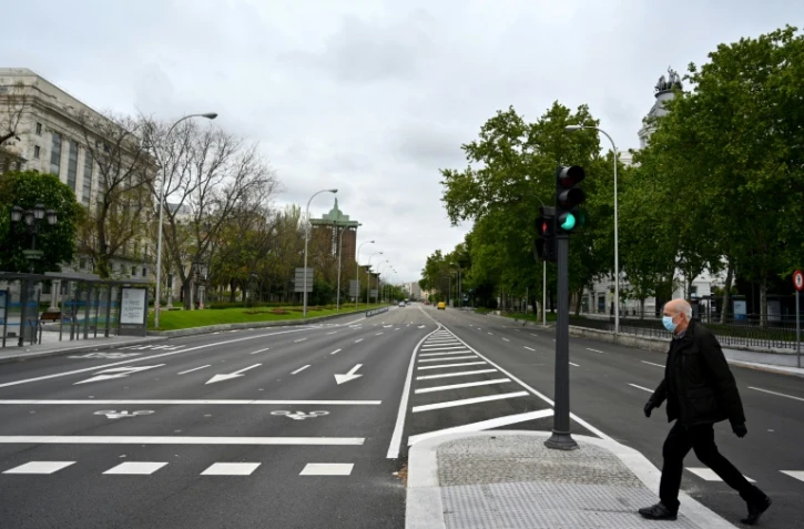 Un homme traverse une avenue dans un Madrid désert, le 21 avril 2020