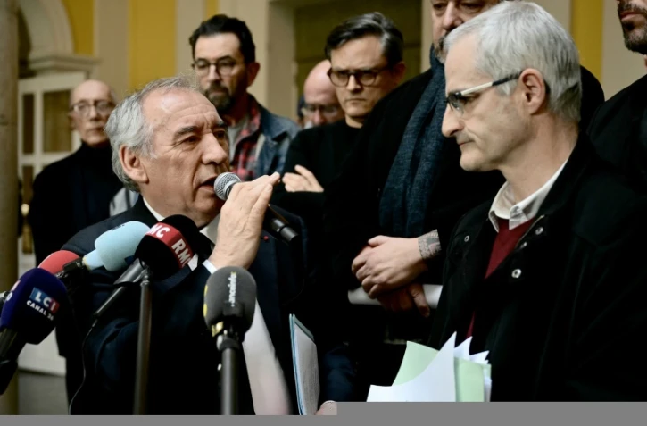 Le Premier ministre français François Bayrou (G) s'adresse à la presse après une rencontre avec des membres du collectif des victimes de violences de Notre-Dame-de-Betharram et son porte-parole Alain Esquerre (D) à la mairie de Pau, dans le sud-ouest de la France, le 15 février 2025