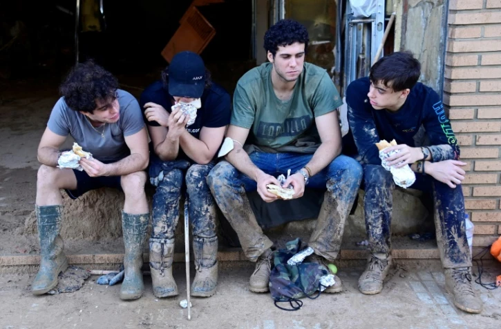 De jeunes se reposent après le nettoyage de Paiporta, dans la région de Valence, le 4 novembre 4, 2024