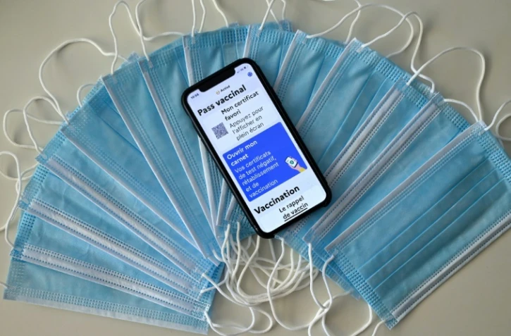 Des masques sanitaires et un carnet de vaccination affiché sur l'écran d'un téléphone portable à Montpellier le 27 janvier