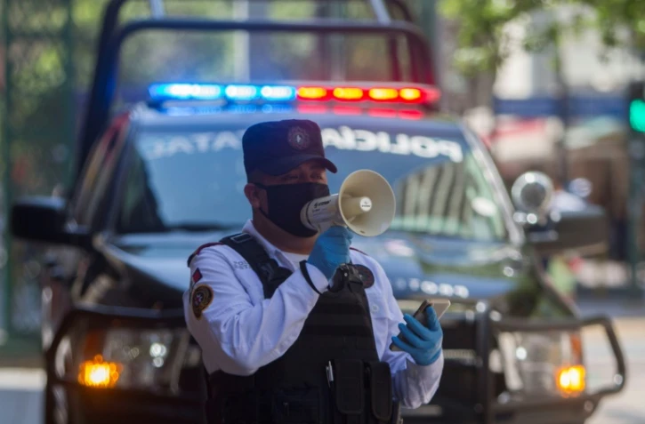 Un policier utilise un haut-parleur pour inviter les passants à rentrer chez eux, le 25 mars 2020 à Monterrey, au Mexique