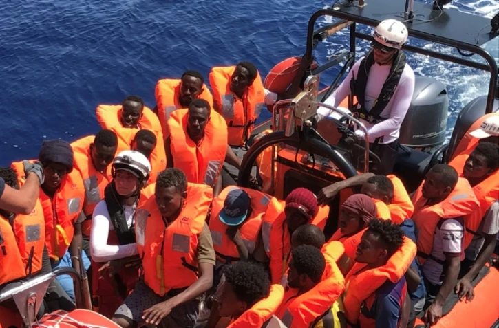 Des migrants secourus dans les eaux internationales au large de la Libye, à bord d'un bateau pneumatique appartenant au navire humanitaire Ocean Viking le 12 août 2019. L'Ocean Viking, affrété par SOS Méditerranée et Médecins sans frontières, a secouru lundi 105 migrants supplémentaires dans ces eaux, et compte désormais 356 personnes à bord.