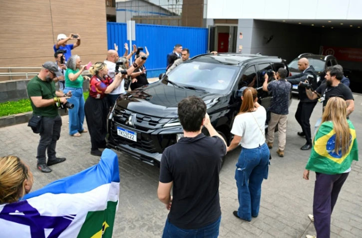 Un véhicule transportant l'ancien président brésilien Jair Bolsonaro quitte la clinique privée DF Star à Brasilia, le 17 septembre 2025