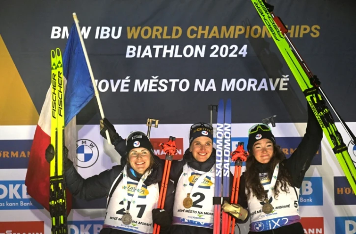 (De gauche à droite) Les biathlètes françaises Justine Braisaz-Bouchet, Julia Simon et Lou Jeanmonnot célèbrent leur triplé sur le podium du sprint remporté par Julia Simon aux Championnats du monde de biathlon à Nove Mesto, République Tchèque, le 9 février 2024