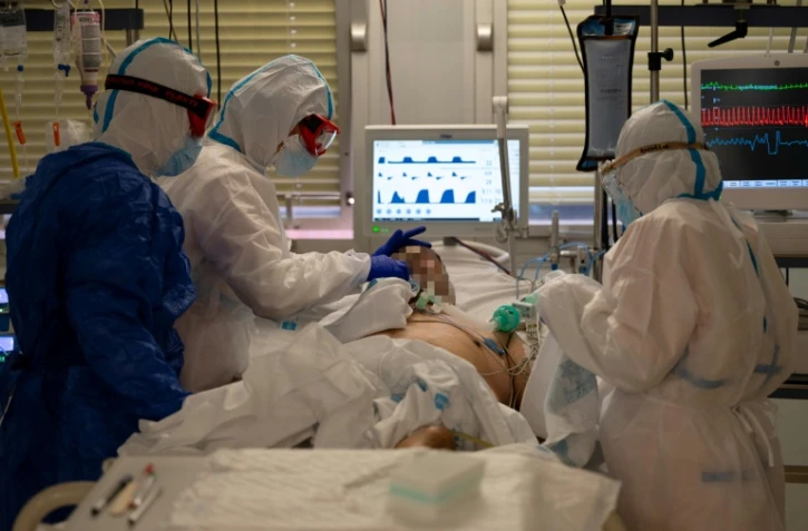 Des soignants en combinaison intégrale de protection s'occupent d'un patient atteint du coronavirus dans l'unité de soins intensifs de l'hôpital universitaire Severo Ochoa, le 16 octobre 2020 à Leganés, dans la banlieue de Madrid