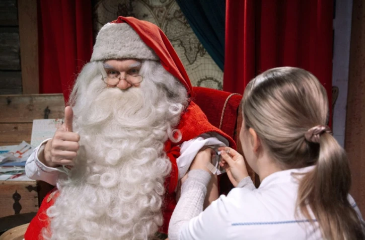 Le Père Noël se fait vacciner par son infirmière Tiia Kahkone à Rovaniemi, sur le Cercle polaire arctique de Finlande, le 1er novembre 2018