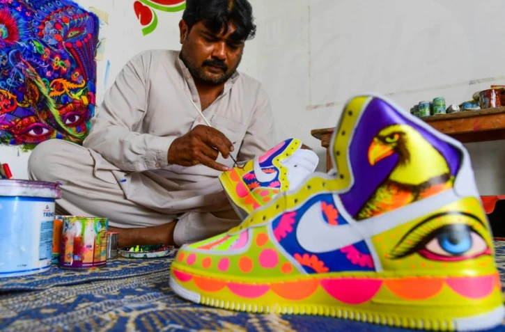 L’artiste Haider Ali peint une paire de baskets dans son studio de Karachi, le 28 février 2022