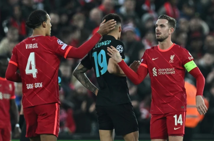 Les joueurs de Liverpool Virgil van Dijk (g) et Jordan Henderson (d) encadrent le milieu de l'inter Joaquin Correa à la fin de leur match de ligue des champions, le 8 mars 2022 à Liverpool