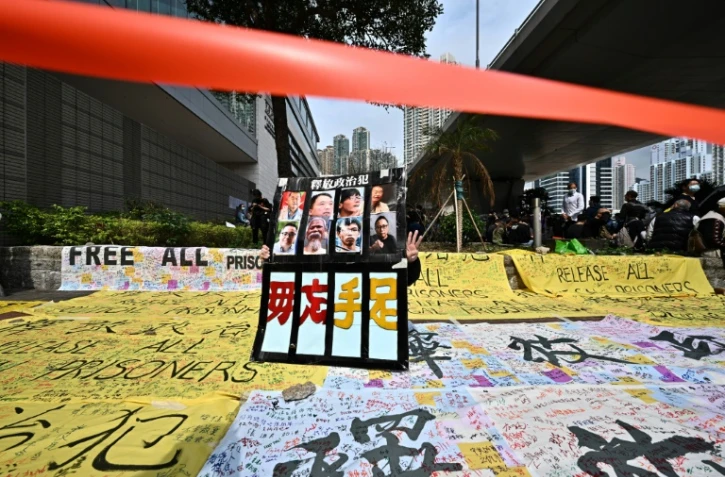 Un manifestant se tient derrière une pancarte devant le tribunal de Kowloon à Hong Kong le 1er mars 2021 