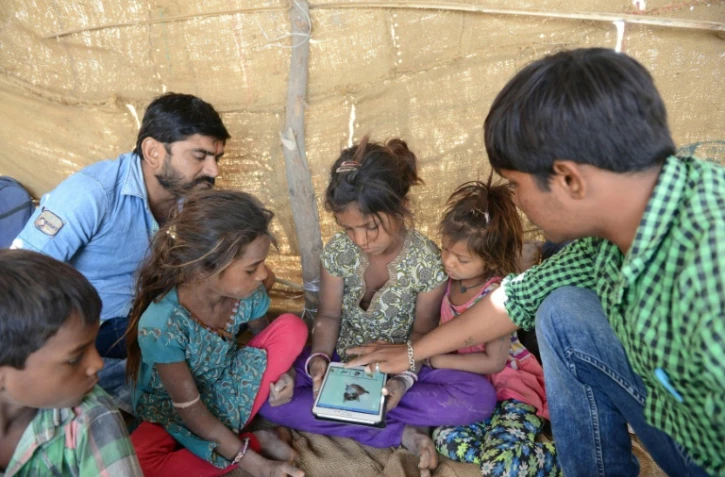 Anand Solanki (D) fait découvrir internet à des enfants du désert du Gujarat, en Inde, le 7 avril 2017