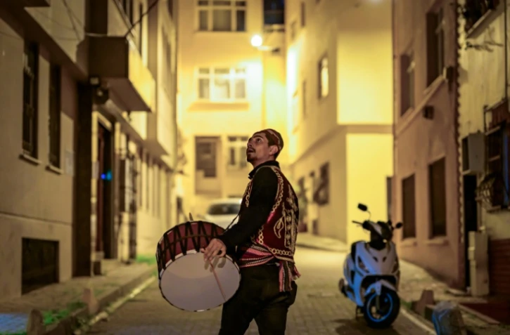 Un joueur de davul, tambour à deux faces, sonne l'heure du dernier repas avant d'entamer le jeûne du ramadan à l'aube, le 24 février 2026 à Istanbul