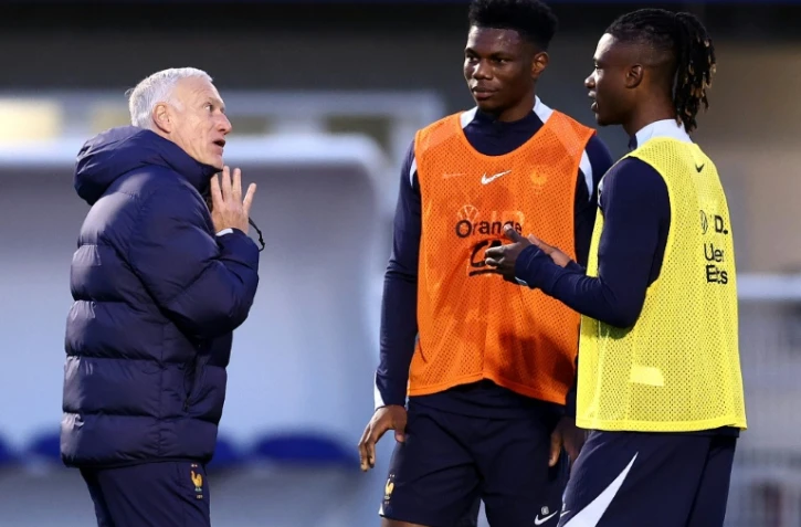 Aurélien Tchouameni (au centre) discute avec le sélectionneur Didier Deschamps et son coéquipier Eduardo Camavinga durant l'entraînement mardi 19 mars 2024 à Clairefontaine-en-Yvelines.