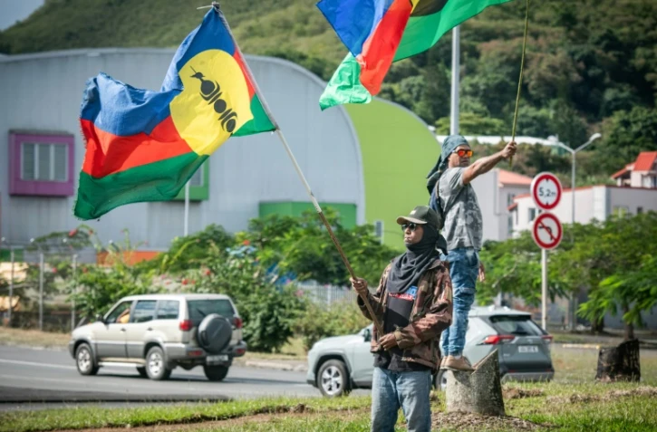 Des partisans de l'indépendance de la Nouvelle-Calédonie brandissent des drapeaux kanak, le 27 juin 2024 à Nouméa