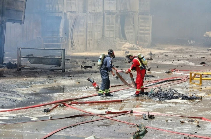 Photo fournie par le Croissant-Rouge iranien (IRCS), le 28 avril 2025, de pompiers sur les lieux d'une explosion massive deux jours plus tôt dans le port Shahid Rajaï, dans la province d'Hormozgan, en Iran