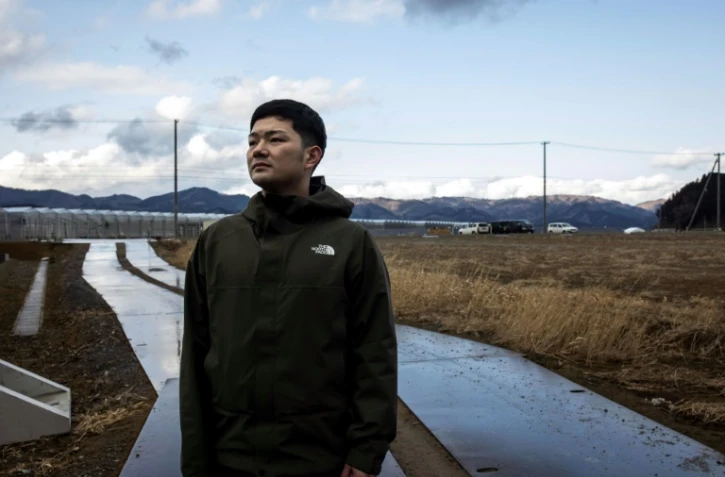 Yuto Naganuma, 26 ans, devant l'école primaire où son petit frère a perdu la vie pendant le tsunami de 2011, le 7 février 2021 à Ishinomaki, au Japon