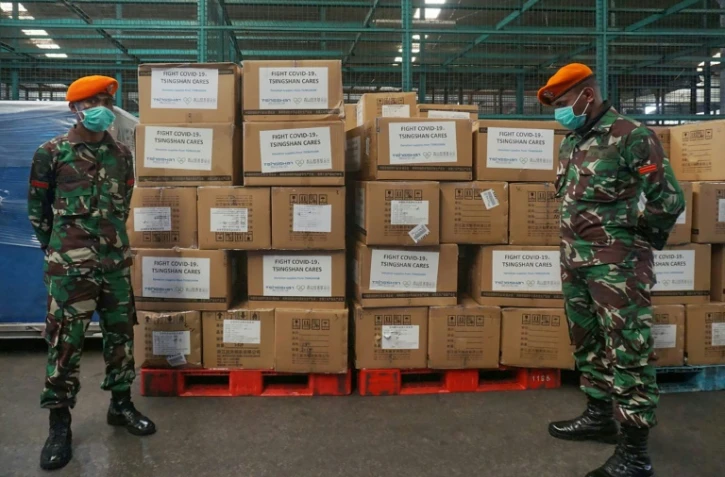 Deux militaires encadrent des cartons de produits et équipements médicaux envoyés par la Chine, à l'aéroport Tangerang de Jakarta, le 27 mars 2020