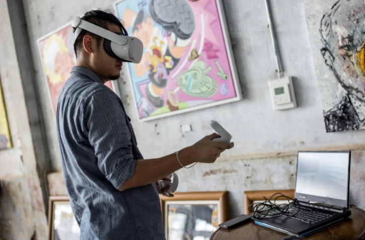 L'artiste thaïlandais Chalermpol Junrayab utilise un casque de réalité virtuelle pour ses oeuvres exposées à la galerie Lhong 1919, le 16 novembre 2020 à Bangkok