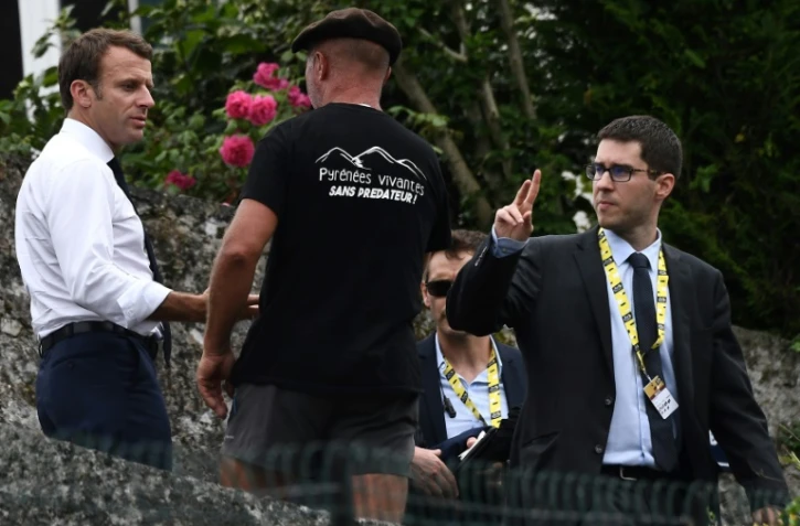 Emmanuel Macron (g)salue un habitant de Tourmalet lors de la 14e étape du Tour de France entre Tarbes et le col du Tourmalet, le 20 juillet 2019 