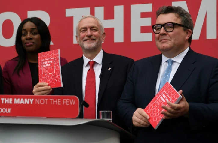 Le dirigeant du Parti travailliste britannique Jeremy Corbyn (c), entouré de Kate Osamor et Tom Watson, deux hauts responsables du parti, présente le manifeste travailliste pour les législatives de juin, le 16 mai 2017 à Bradford