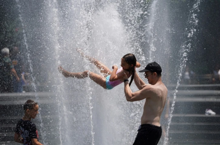 Des habitants de New York, placée en alerte canicule, se rafraîchissent dans une fontaine