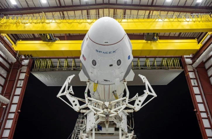 La capsule Crew Dragon au sommet d'une fusée Falcon 9 de SpaceX, à l'horizontale, à la sortie d'un hangar au centre spatial Kennedy, en Floride, 
le 21 mai 2020