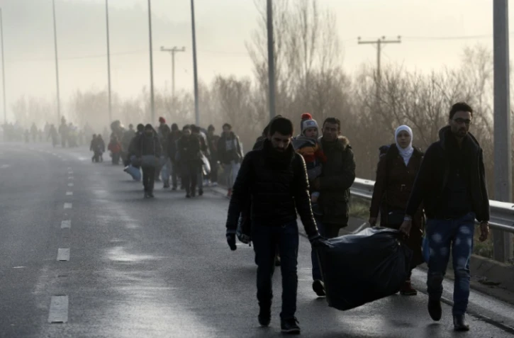 Des migrants et des réfugiés traversent la frontière gréco-macédonienne près du village grec d'Idomeni, le 1er mars 2016 on 1 March, 2016