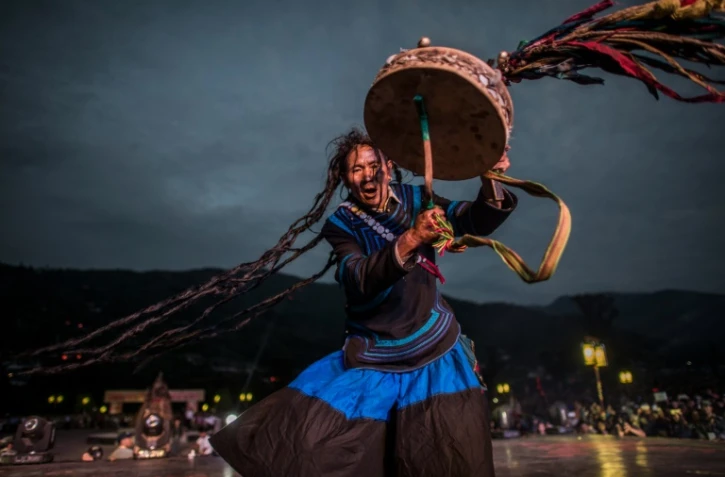 Un chamane en costume Yi traditionnel à Xichang, le 27 juillet 2016