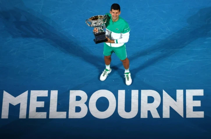 Le Serbe Novak Djokovic pose avec son trophée, après avoir remporté l'Open d'Australie face au Russe Daniil Medvedev, le 21 février 2021 à Melbourne