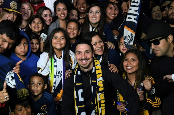 L'attaquant suédois Zlatan Ibrahimovic (c) est accueilli par des supporters à l'aéroport de Los Angeles, le 29 mars 2018