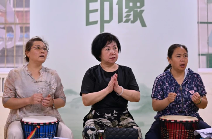 Des participantes à un cours de tambour africain dans une ancienne garderie pour enfants transformée en centre de loisirs pour retraités, le 2 juillet 2024 à Taiyuan, dans le nord de la Chine