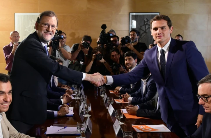 Le Premier ministre espagnol  Mariano Rajoy (g) et le responsable de Ciudadanos Albert Rivera, se serrent les mains à Madrid, le 28 août 2016