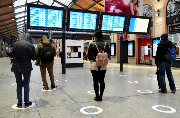Des passagers Ă la gare Saint-Lazare Ă Paris, le 11 mai 2020 respectent les marquages au sol de distanciation sociale