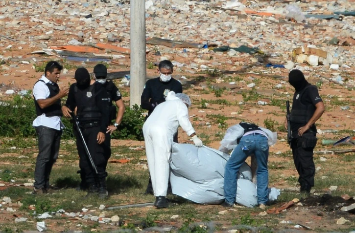 Des médecins légistes recouvrent des restes de corps découverts dans la prison d'Alcaçuz, près de Natal, le 21 janvier 2017 au Brésil