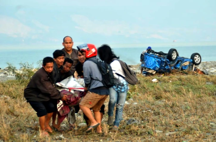 Un corps porté le 29 septembre 2018 par des habitants de Palu après un fort séisme sur l'île indonésienne des Célèbes.