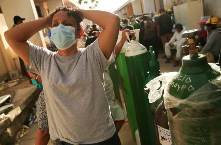Des proches de malades du Covid-19 font la queue pour faire recharger des bouteilles d'oxygène à l'hôpital d'Iquitos, au Pérou, le 14 mai 2020