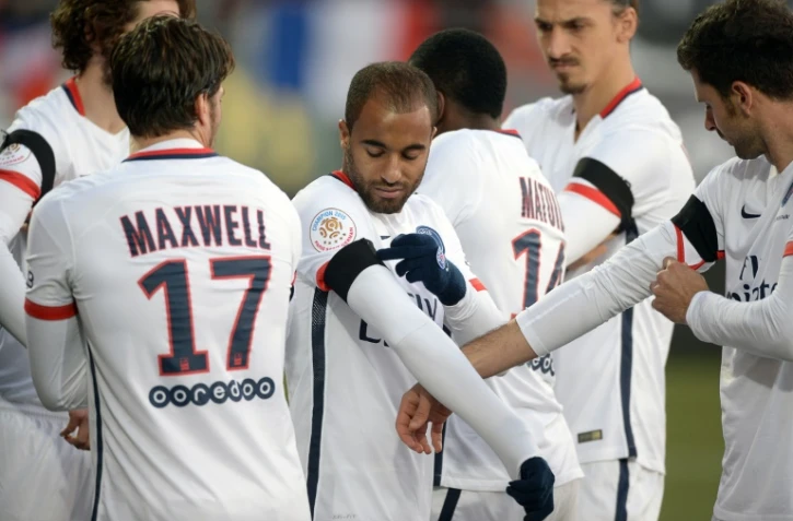 Les joueurs du PSG, opposés à Lorient, ajustent le brassard noir en hommage aux victimes des attentats, le 21 novembre 2015 au stade du Moustoir