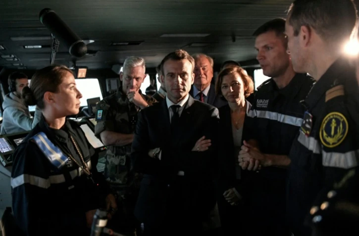 Emmanuel Macron dans la passerelle du porte-avions Charles de Gaulle en compagnie de la ministre de la Défense Florence Parly, du chef des armées le général Francois Lecointre et l'équipe de commandement du vaisseau, en Méditerrannée le 14 novembre 2018