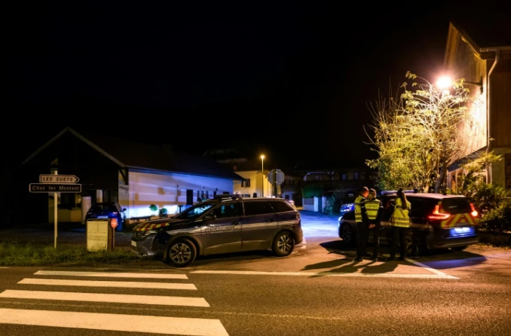 Des gendarmes à l'entrée de la rue où trois enfants ont été retrouvés morts dans une habitation, le 12 novembre 2024 à Taninges, en Haute-Savoie