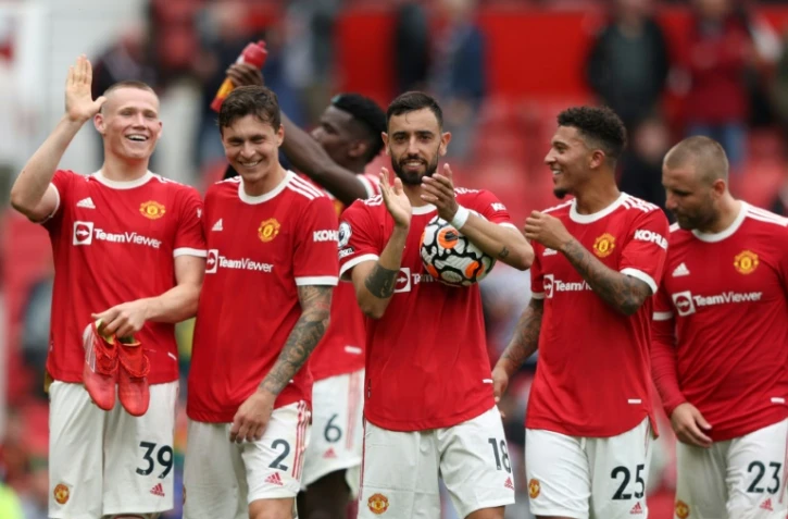 Le milieu de terrain portugais de Manchester United, Bruno Fernandes (c), auteur d'un triplé, et ses coéquipiers, saluent les supporters, après la victoire (5-1) contre Leeds, lors de la 1ère journée de la Premier League, le 14 août 2021 à Old Trafford 
