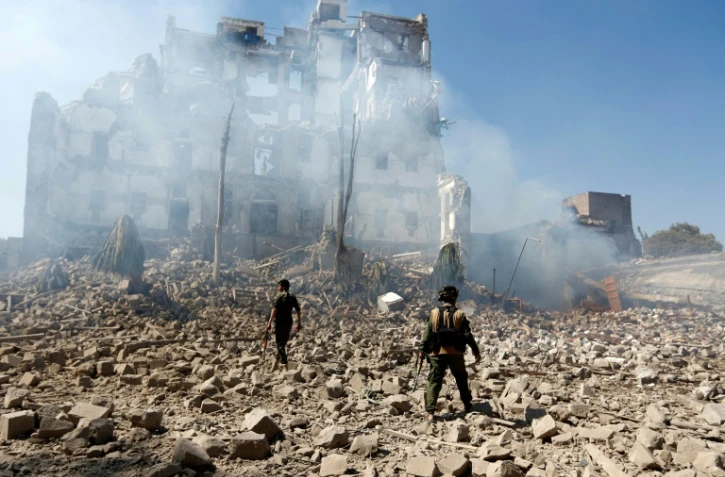 Des rebelles Houthis inspectent les dégâts, le 5 décembre 2017, après une frappe aérienne attribuée à la coalition militaire menée par Ryad contre le palais présidentiel à Sanaa, 