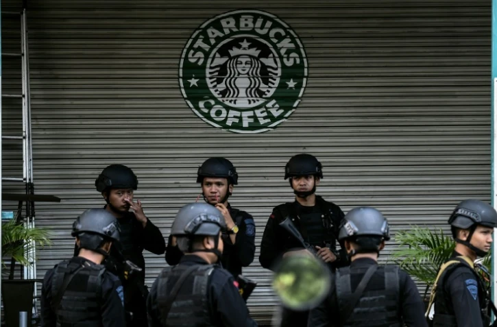 Des policiers indonésiens devant le café initialement visé par les terroristes à Jakarta, le 16 janvier 2016