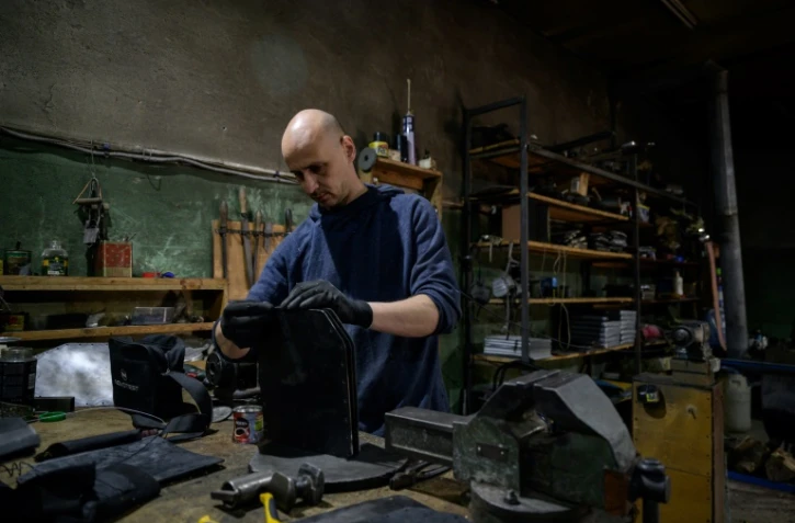 Vadim Mirnichenko prépare des plaques de métal qui serviront à fabriquer des protections pare-balles, le 1er mai 2022 dans son atelier de Zaporijjia, en Ukraine