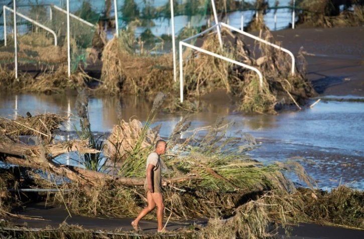 Un homme le long du fleuve Tamagawa à Kawasaki le 13 octobre 2019, après le passage du typhon Hagibis
